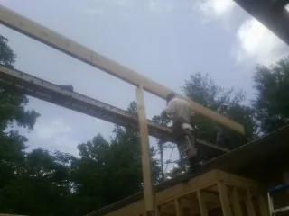 Carpenter setting a ridge beam over a new addition frame — Ice Dam Removal by Roofing Brothers in Hildale