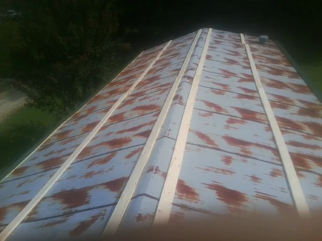 Rusted metal roof panels with new wood purlins before replacement — Storm Damage Roof Repair in Hildale by Roofing Brothers