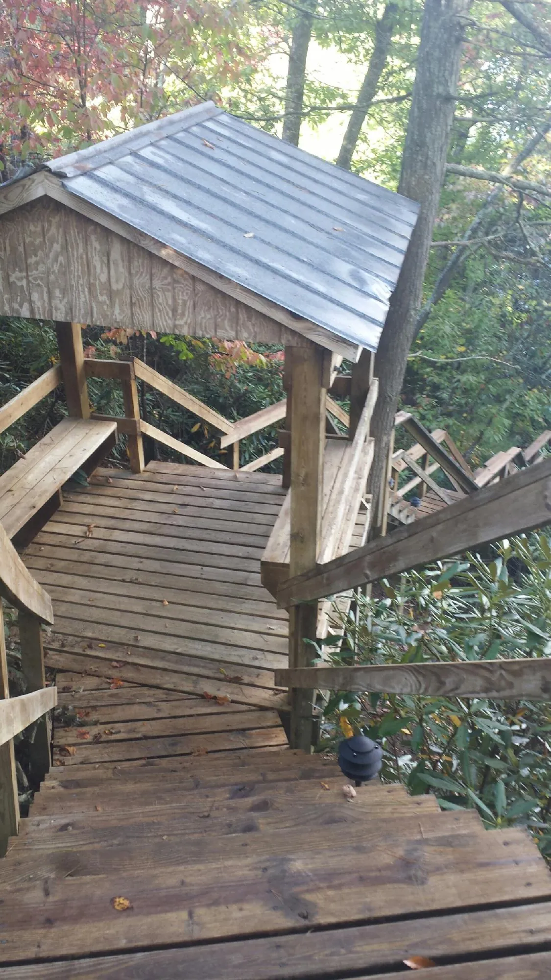 Metal roofed shelter over wooden steps on a wooded walkway — Skylight Repair & Installation work by our crew in Hildale